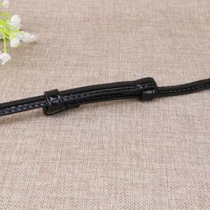 Détail de ceinture fine en cuir verni noir, design ajustable minimaliste pour robes et pulls.