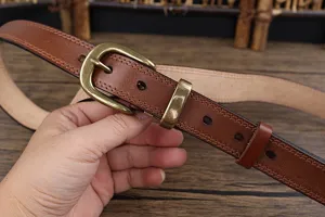 Close-up detail of the vintage brown leather belt, showing fine stitching and classic metal buckle.