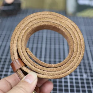 Detailed view of the rolled genuine leather belt, highlighting the raw texture and fine edge.
