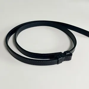 Close-up detail of a slim black leather belt with neat stitching, elegant and versatile.