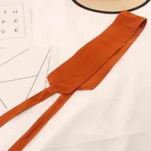 Detalle de cinturón de ante naranja, cinta de terciopelo suave para mujer, accesorio versátil.