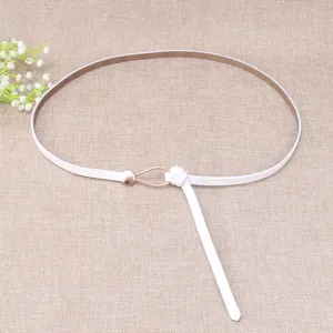 Details of white thin leather belt with gold waterdrop buckle on textured backdrop.