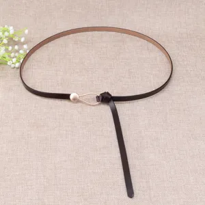 Detail view of the elegant brown thin leather belt with a chic teardrop metal buckle design.