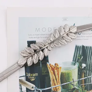 Detailed close-up of a silver leaf metal elastic waist chain, perfect dress accessory.