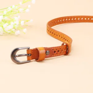 Detailed shot of brown hollow leather belt with metal buckle, elegant women accessory.