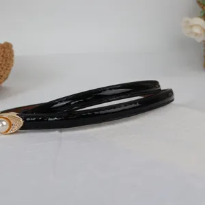 Chic women's thin black patent leather belt with elegant pearl gold buckle for dresses.