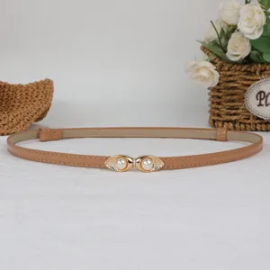 Detail view of the elegant thin leather waist belt with gold pearl buckle for dresses.
