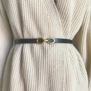 Cinturón fino de cuero minimalista con hebilla de metal dorada, elegante accesorio de cintura.
