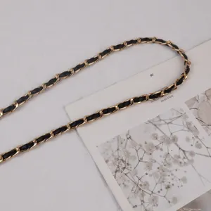Detailed view of women fashion leather intertwined gold metal chain belt accessory.