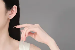 Close-up detail shot of a square minimalist moissanite stud earring on a model's ear