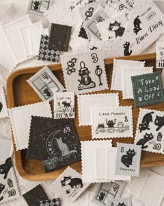 Gros plan d'autocollants timbre chat noir, papeterie rétro gaufrée pour le journal.