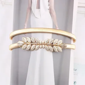 Close-up detail of a gold metal elastic waist chain featuring an exquisite leaf buckle.