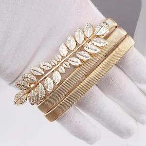 Gold metal leaf stretch waist belt detail, elegant dress accessory for women fashion wear.