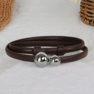 Detailed view of a slim brown leather belt featuring dual silver sphere metal clasps closeup.