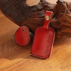 Closeup of handmade red leather access card holder and teardrop key cover with brass rivet.