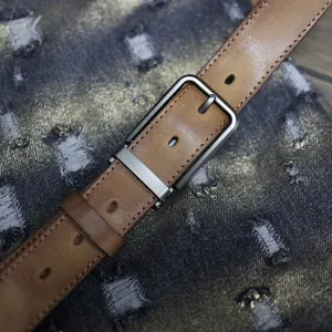 Detailed shot of vintage handmade genuine leather belt for men with antique metal pin buckle.