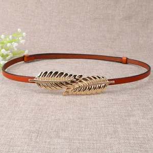 Detailed view of thin brown leather belt with elegant golden leaf buckle for dresses.