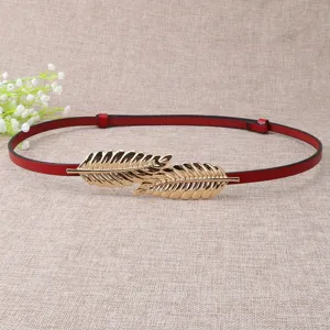 Close-up of the red thin leather belt featuring a shining gold leaf metal buckle detail.