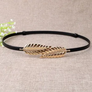 Detailed view of women thin black belt with elegant gold leaf metal buckle, dress accessory.