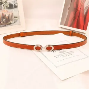 Delgada correa de cuero naranja para mujer con hebilla plateada, ideal para vestidos y abrigos.