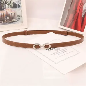 Elegante fina correa de cuero marrón para mujer con hebilla de doble anillo plateada.