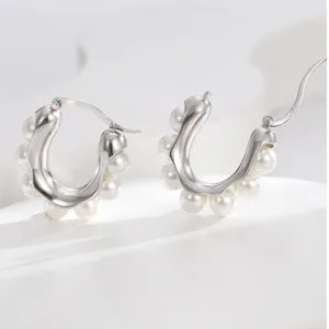 Primo piano di eleganti orecchini in argento a forma di U decorati con piccole perle