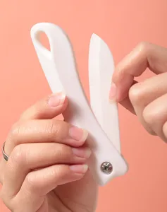 Gros plan d'un couteau pliant portable en céramique blanche ouvert à la main