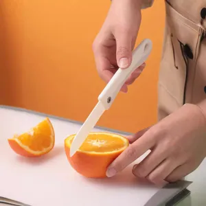 Couteau à fruits pliable en céramique pour trancher des oranges sur une planche