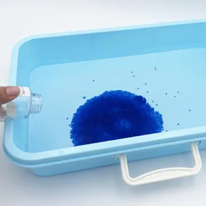 Detailed view of DIY expanding water beads in blue tray for kids sensory play and fun activities.