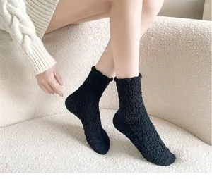 Cozy black fuzzy fleece detail shot, thick warm winter sleeping socks on soft sofa display.