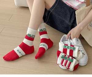 Detail view of red and white cotton blessing socks worn by model with sneakers in lifestyle setting.