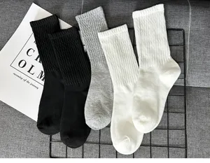Ribbed crew socks detail view featuring classic black, grey and white cotton knit design.