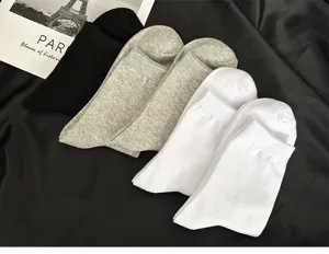 Nahaufnahme Detail klassischer einfarbiger Herrensocken in Schwarz, Grau und Weiß.