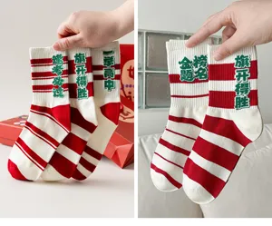 Detail view of exam blessing cotton socks with red white stripes and Chinese lucky text.