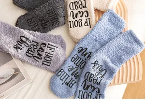 Cozy fuzzy coral fleece floor socks with non-slip grip lettering on sole for warm winter wear.