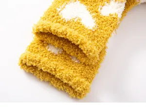 Close-up detail of soft coral fleece winter warm fuzzy socks with cute heart pattern for home.