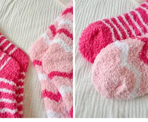 Soft cozy coral fleece fuzzy socks detail closeup, pink white striped warm winter home sleep socks.