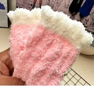 Close-up detail of fluffy coral fleece women socks in pink and white cozy winter design.
