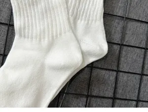 Close-up view of white ribbed cotton socks showcasing fine texture and elastic top design.