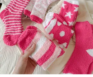 Soft coral fleece fuzzy socks detail showing cute pink white patterns for winter home.