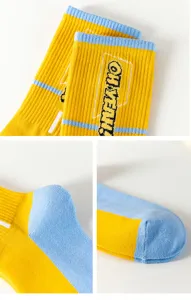 Close-up detail shot of stylish hip-hop color-block mid-tube socks with knit cuff lettering.