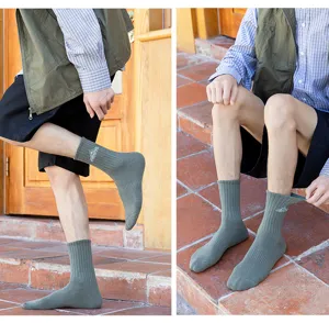 Detail view of men's ribbed mid-calf cotton socks featuring stylish mountain embroidery.
