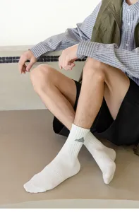 Men's white mid-tube cotton socks with green embroidered mountain and letters for casual daily streetwear.