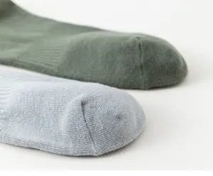 Close-up detail shot of knitted mid-tube cotton socks in green and light blue colors.