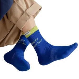 Men's blue cotton mid-tube socks with green cuff splice and side label trend design.