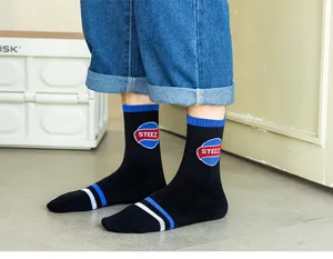 Close-up detail of black men's mid-tube cotton socks with stylish blue and white striped accents.
