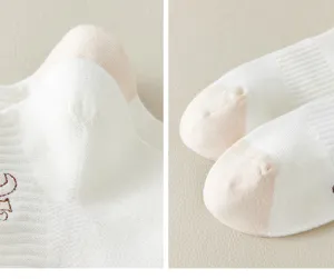 Detail view of cute women's short socks, white cotton fabric with contrast color heel and sweet embroidery.