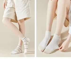Detailed shot of breathable white short socks featuring brown stripes and embroidered detail.
