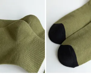 Vista detallada de calcetines para hombre con fina textura de punto, verde oliva y puntera negra.