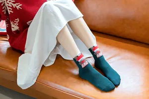 Détail en gros plan de chaussettes mi-hautes de Noël pour femmes avec adorables peluches 3D.
